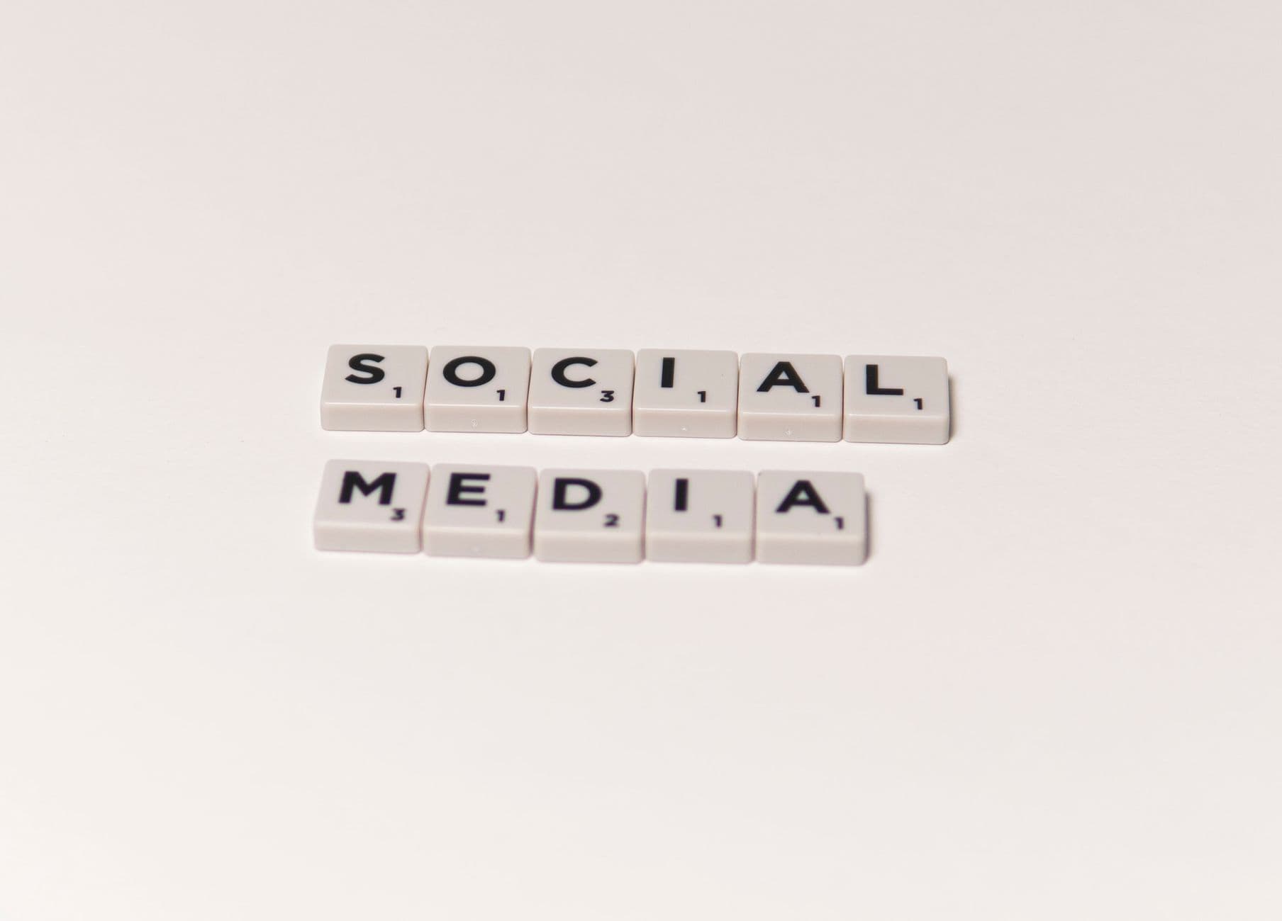 Scrabble tiles spelling 'social media' on a white background, representing digital communication concepts.