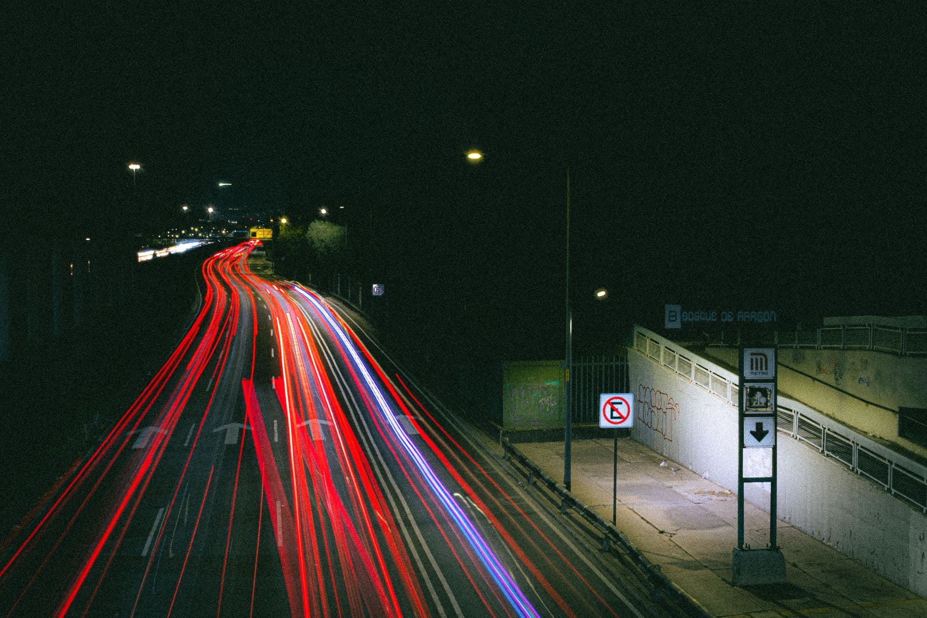 Dramatic long exposure of vibrant traffic lights on a city highway at night.
