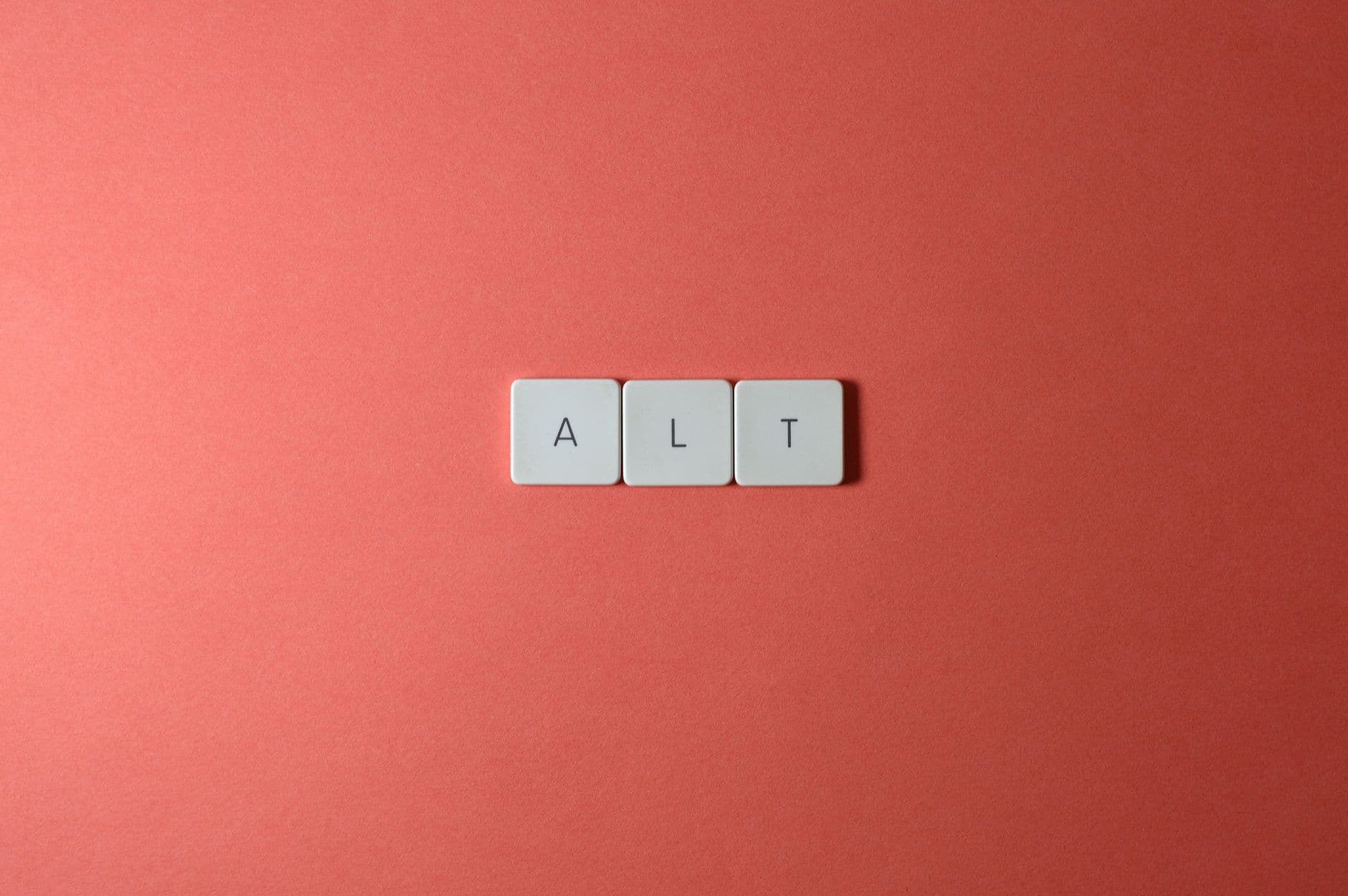 Close-up of ALT keycaps on a coral background, perfect for tech or minimalist themes.