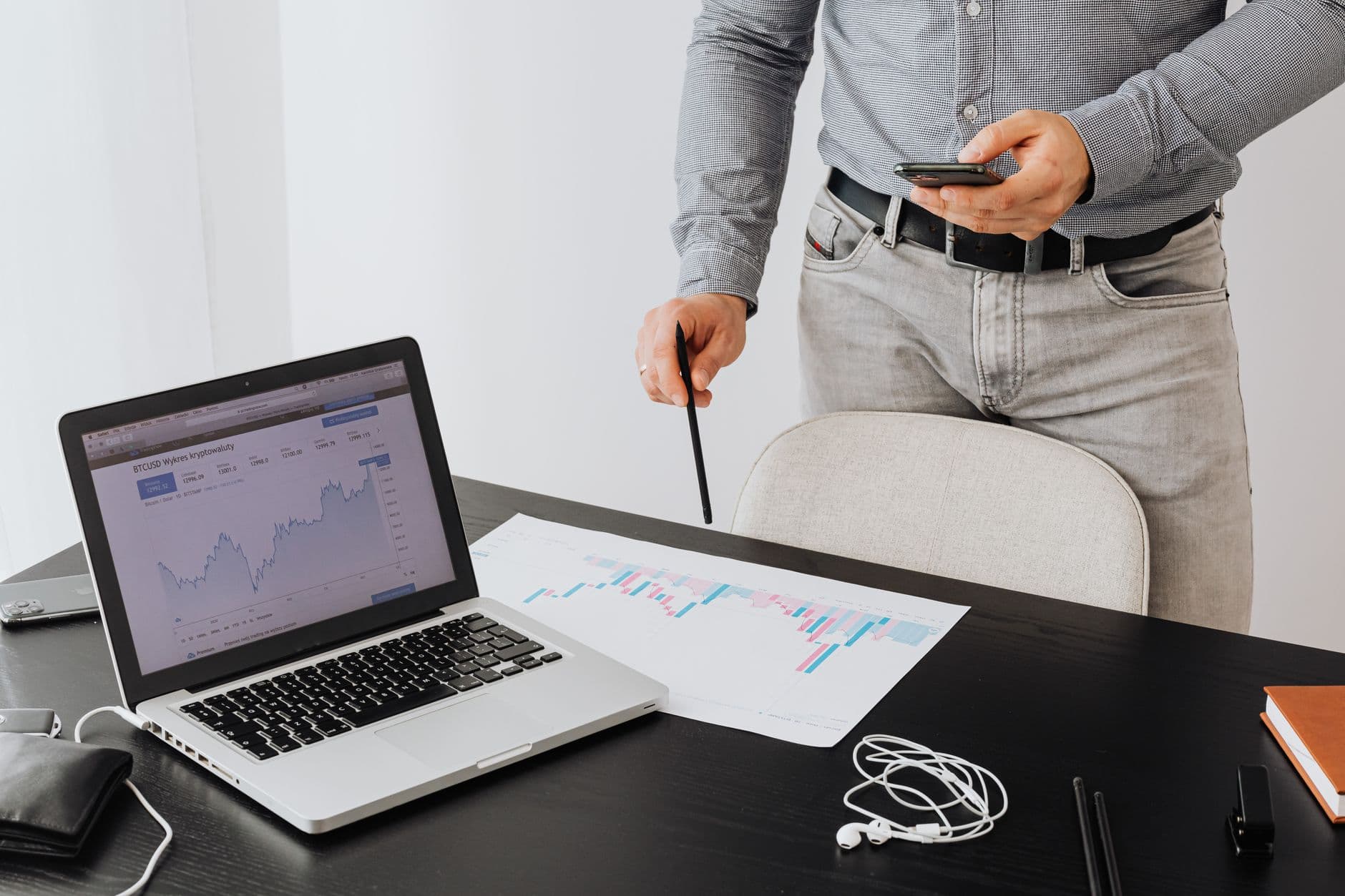Business professional analyzing cryptocurrency trends on a laptop with graphs and charts.