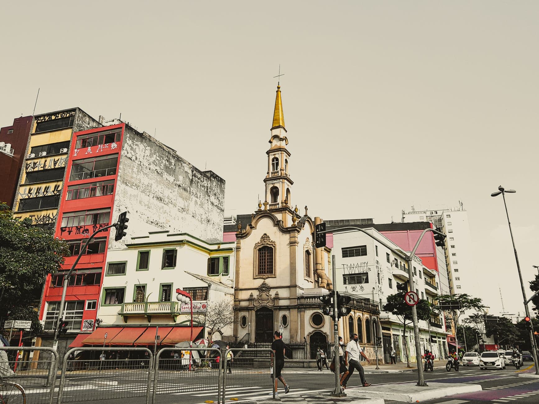 A vibrant cityscape featuring a historic church amidst urban buildings and street life.